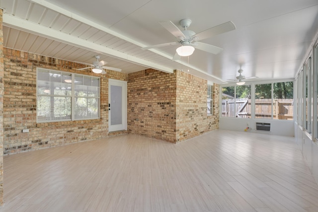 unfurnished sunroom with beam ceiling and a wall mounted air conditioner