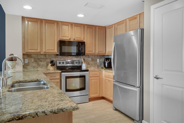 kitchen with decorative backsplash, light hardwood / wood-style floors, sink, and stainless steel appliances