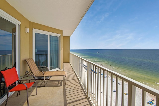 balcony featuring a beach view and a water view