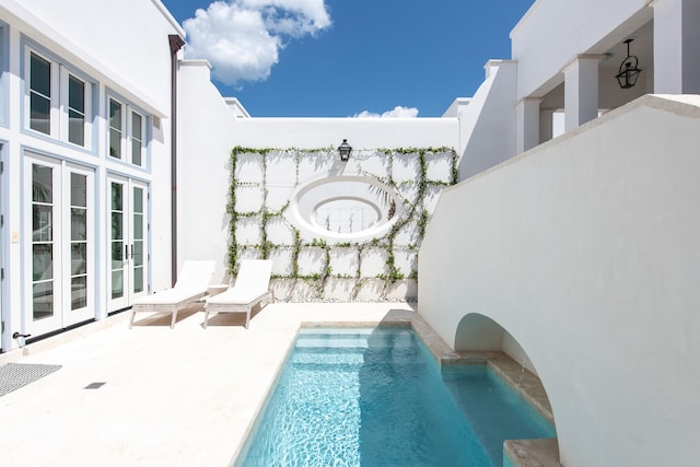 view of pool with french doors and a patio