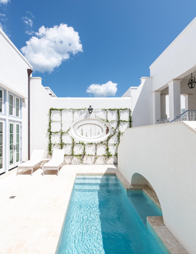 view of swimming pool featuring a patio area and french doors