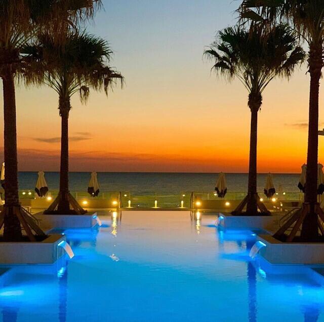 pool at dusk featuring a water view