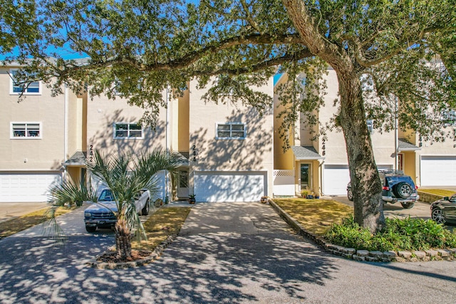 view of property featuring stucco siding, an attached garage, and driveway