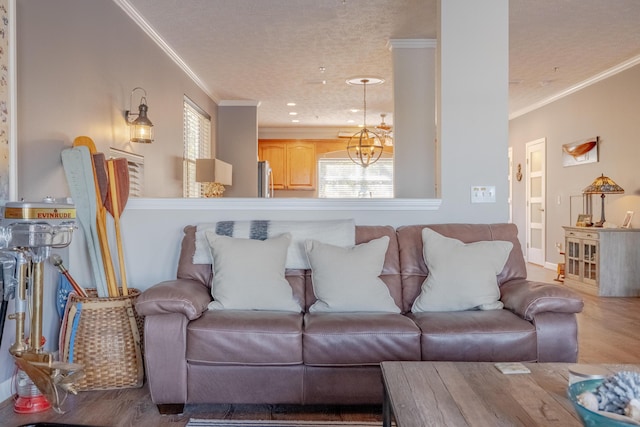 living room featuring wood finished floors, a chandelier, and ornamental molding