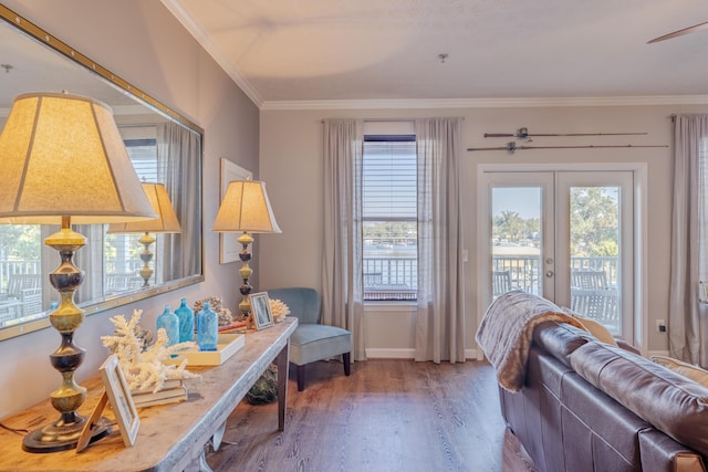 living area with a healthy amount of sunlight, french doors, crown molding, and wood finished floors