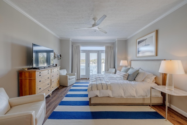 bedroom with access to exterior, a textured ceiling, crown molding, and wood finished floors