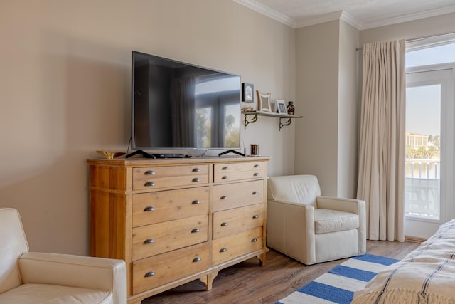 bedroom with light wood-style floors and ornamental molding