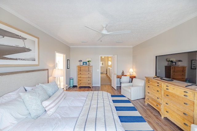 bedroom featuring a ceiling fan, wood finished floors, a textured ceiling, crown molding, and connected bathroom