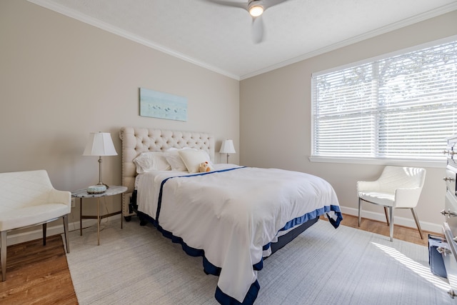 bedroom featuring baseboards, wood finished floors, a ceiling fan, and ornamental molding