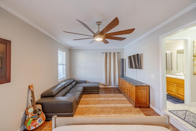 living area featuring ceiling fan, light wood-style floors, baseboards, and ornamental molding