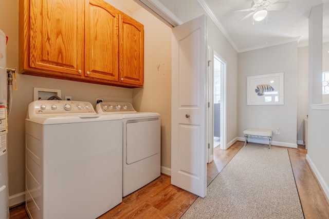 clothes washing area featuring a healthy amount of sunlight, ornamental molding, light wood-style flooring, cabinet space, and independent washer and dryer