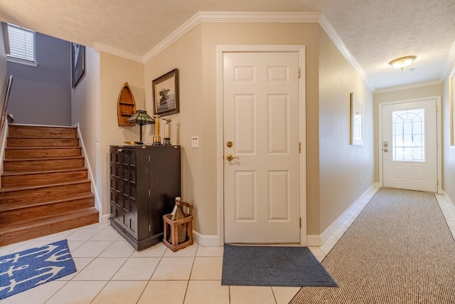 foyer entrance with a textured ceiling, light tile patterned flooring, stairs, and crown molding