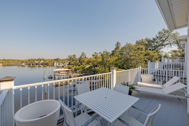 balcony featuring a water view and outdoor dining space