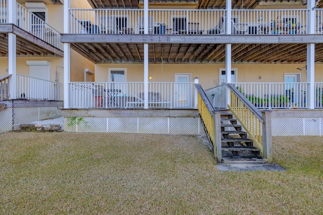 entrance to property with stucco siding and a lawn