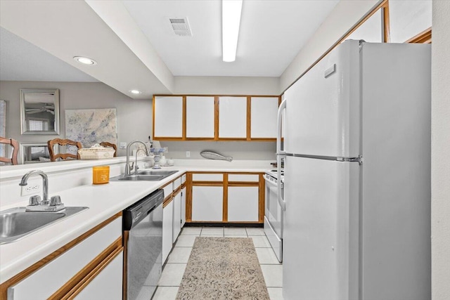 kitchen featuring white appliances, visible vents, light countertops, white cabinetry, and a sink