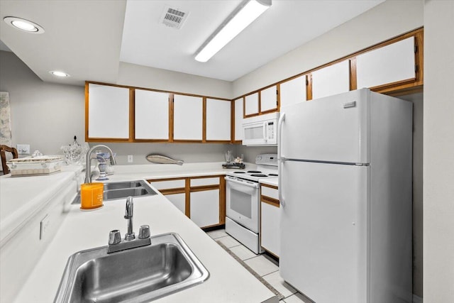 kitchen featuring white appliances, light countertops, and white cabinetry