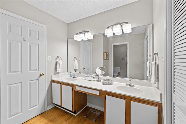 full bath featuring a textured ceiling, a closet, a sink, and toilet