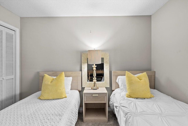 bedroom with a closet, carpet flooring, and a textured ceiling