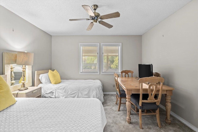 bedroom featuring light carpet, ceiling fan, a textured ceiling, and baseboards