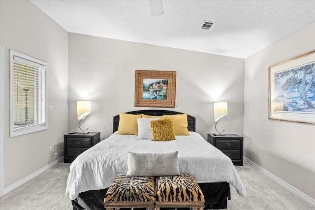 bedroom featuring baseboards, a textured ceiling, and light colored carpet