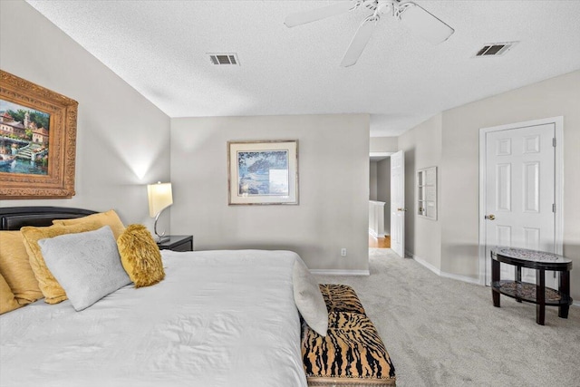 bedroom with baseboards, a textured ceiling, visible vents, and light colored carpet