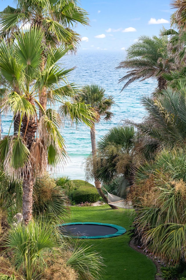 view of community with a yard, a water view, and a trampoline