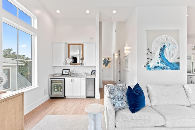 living room featuring wet bar, light hardwood / wood-style floors, and wine cooler