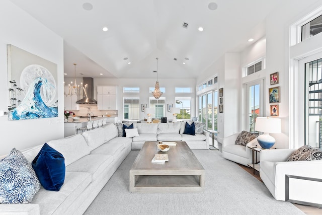 living room with high vaulted ceiling and a notable chandelier