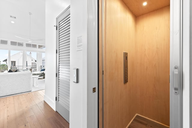 hallway with wood-type flooring and elevator