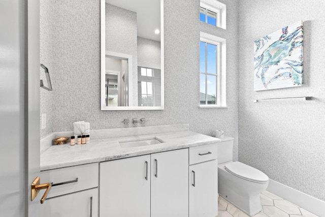 bathroom with toilet, a wealth of natural light, tile patterned floors, and vanity