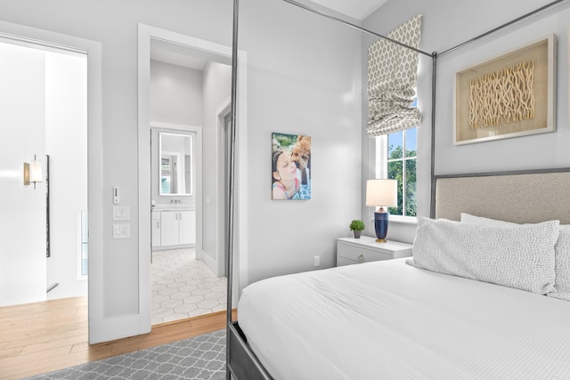 bedroom featuring hardwood / wood-style flooring and connected bathroom