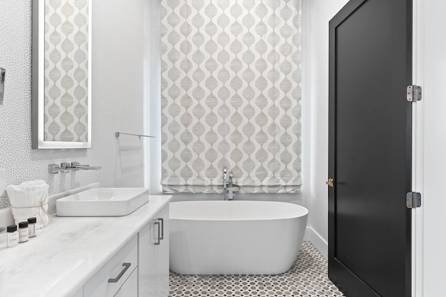 bathroom with a tub, vanity, and tile patterned flooring