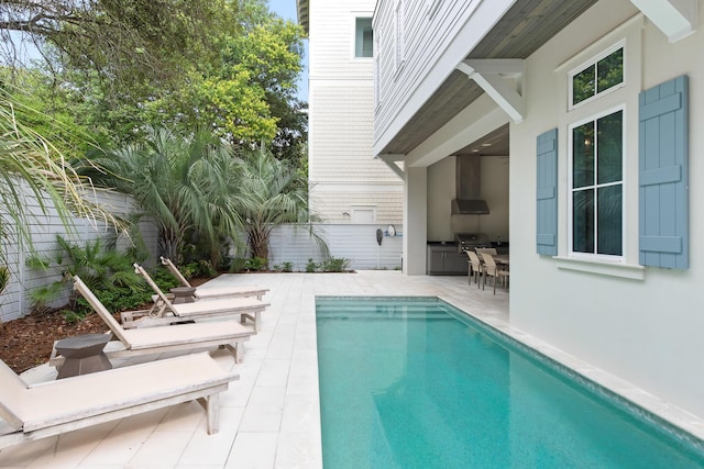 view of pool with a grill, area for grilling, and a patio