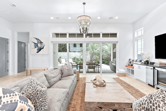 living room with an inviting chandelier, a wealth of natural light, and beverage cooler