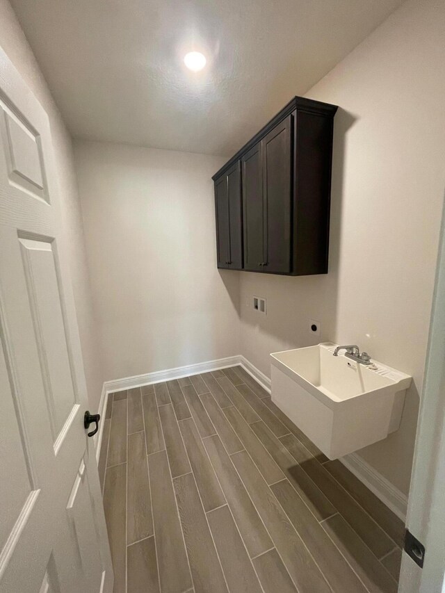846 Coastal Breeze Dr, Freeport, FL 32439 - washroom with washer hookup, baseboards, dark wood-style floors, hookup for an electric dryer, and cabinet space