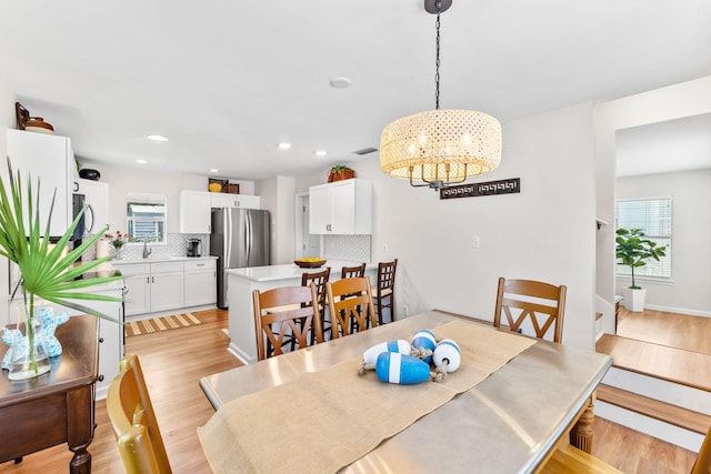 dining space with a chandelier and light hardwood / wood-style flooring