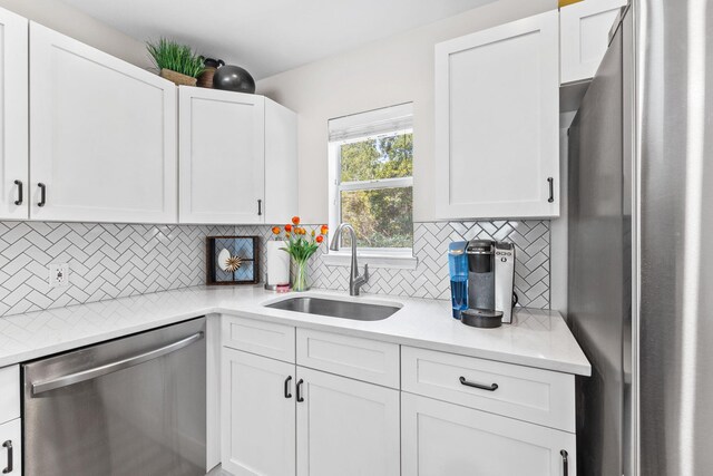 kitchen with stainless steel appliances, sink, and white cabinetry