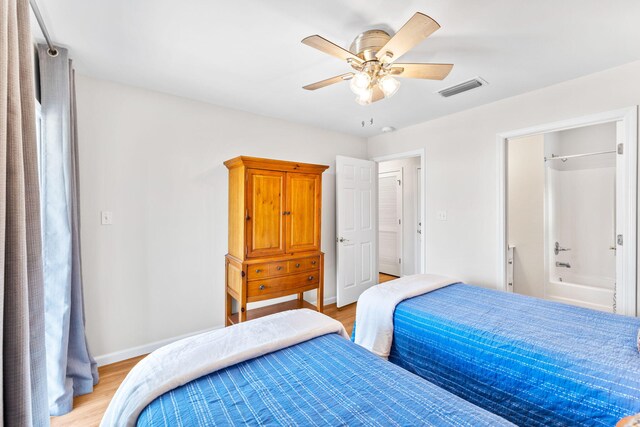 bedroom with light hardwood / wood-style flooring, connected bathroom, and ceiling fan