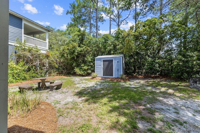 view of yard featuring a balcony and a shed