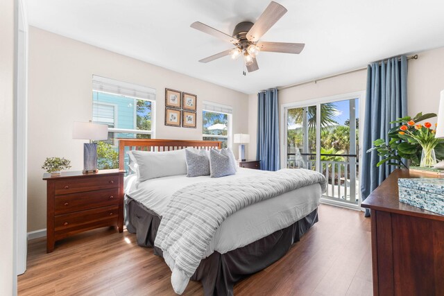 bedroom featuring multiple windows, hardwood / wood-style flooring, and access to exterior