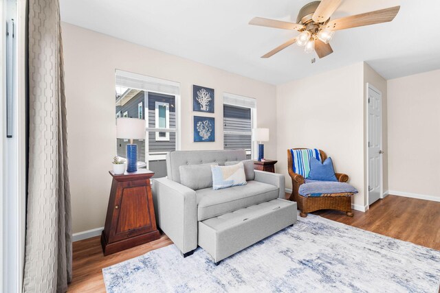 sitting room with hardwood / wood-style floors and ceiling fan