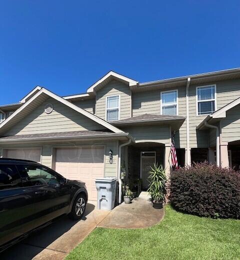 view of front of property featuring a garage and a front lawn