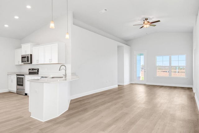 kitchen with sink, white cabinetry, appliances with stainless steel finishes, kitchen peninsula, and pendant lighting