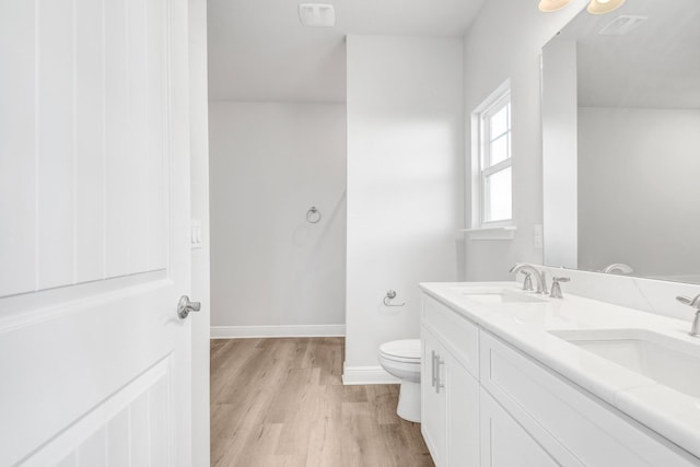 bathroom featuring vanity, hardwood / wood-style floors, and toilet