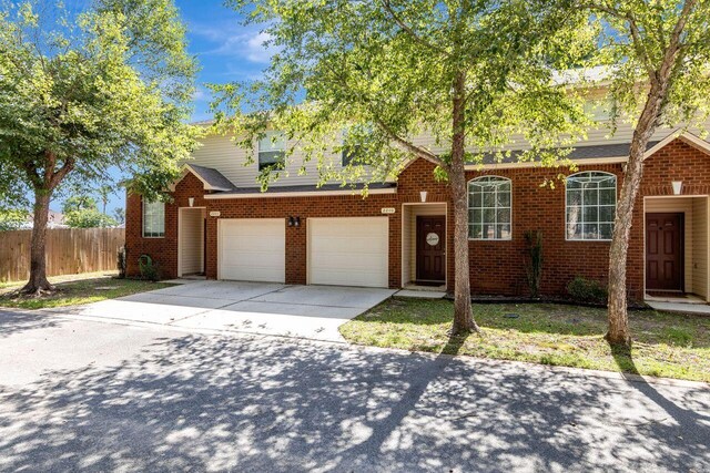 2240 Hadleigh Hills Ct, Navarre, FL 32566 - traditional-style home featuring fence, driveway, brick siding, and a garage