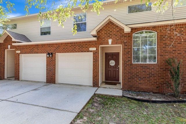 2240 Hadleigh Hills Ct, Navarre, FL 32566 - view of front of home featuring concrete driveway, brick siding, and an attached garage