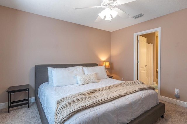 bedroom with ensuite bathroom, carpet floors, and ceiling fan