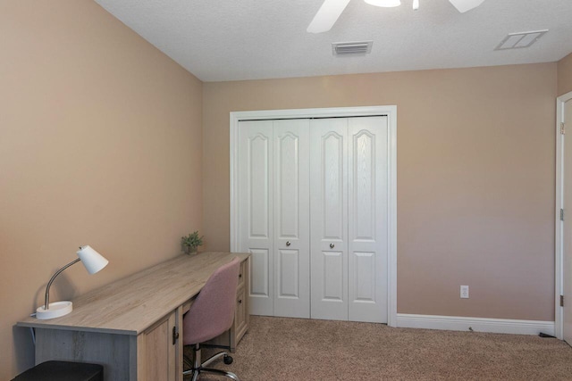 home office featuring carpet floors, a textured ceiling, and ceiling fan