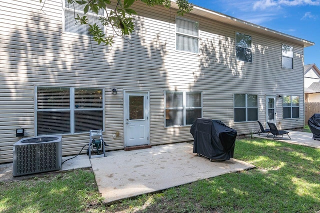 back of property featuring a patio, central air condition unit, and a lawn