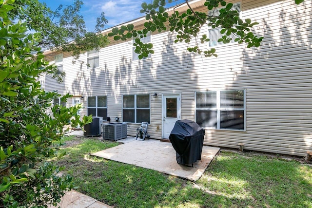 back of property with a yard, central AC, and a patio area